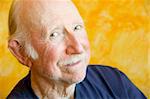 Portrait of an elderly man against a yellow background