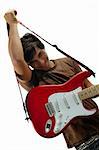 Portrait of trendy teen holding red and white electric guitar - isolated