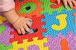 child playing multi colored alphabet puzzle