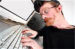 mad programmer sitting at a computer desk