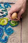Haken einen Teppich, eine traditionelle New England craft, Recyles alten Stoffen in lebendige Matten mit Sackleinen.