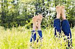 Couple lying in grass stretching their legs up