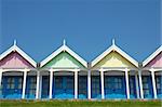 pastel beach huts against a clear blue sky