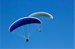 Paraglider soaring in a blue sky