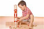 Little boy playing with wooden blocks - isolated