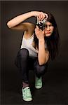 Young girl posing with old camera isolated on black background