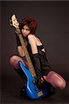 Attractive girl holding bass guitar, studio shot