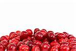 Pile of the red cherries without stalks isolated on the white background