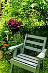 Wooden chair in a secluded corner of lush green garden