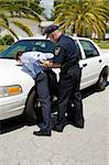 Police officer placing a drunk driver under arrest.