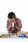 child looking through his microcope, with his glasses on a book