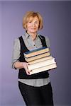 attractive older lady librarian carrying stack of books