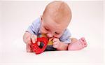 Portrait of cute newborn playing with rattle