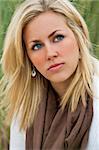 Portrait of beautiful young bond woman looking thoughtful, shot outside in natural daylight