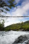 A hanging bridge over a rapid flowing stream