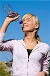 Beautiful girl drinking water under blue sky