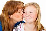 Mother kissing her pretty blond daughter who looks embarassed.  White background.