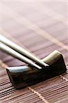 Set of wooden chopsticks on rest close up