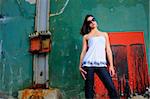 Portrait of young female fashion model posing against grunge abstract background