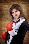 businesswoman with boxing gloves over grunge background