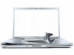 A spanner over a damaged laptop isolated over white background. White copy space on screen.
