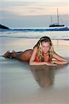 Blonde girl lying on the sand beach