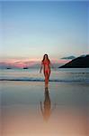 Girl standing on the sunset beach in thailand