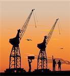 Silhouette of harbour workers and port cranes at sunset sky