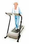 Beautiful senoir woman staying fit by walking on a treadmill.  Isolated on white.