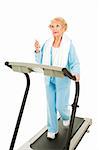 Senior woman listens to her mp3 player while exercising on the treadmill.  Isolated on white.