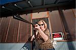 Blonde woman on her front porch with a rifle