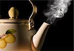 Tea kettle with boiling water on black background