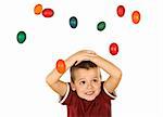 Little boy covering his head to escape the falling easter eggs - isolated, without motion blur