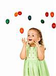 Surprised happy little girl with falling easter eggs - isolated, with added motion blur