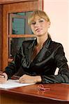 blond girl front desk of hotel reception in formal black suit