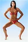 nice girl in red swimwear with a great athletic body taking statuesque pose