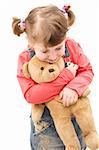 Little girl hugging her teddy bear.