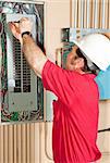 Licensed master electrician working on an industrial breaker panel.