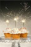 Cupcakes with sparklers on glass cake stand