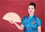 Portrait japanese girl with fan on the red background