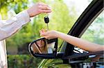 close up of female with arm outstretched taking car keys from man. Copy space