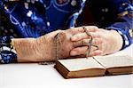 An elderly pair of hands holding a cross
