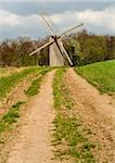 The old windmill to stand on a green field near wood