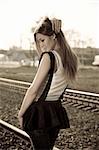 Young beautiful brunette girl standing on the rails