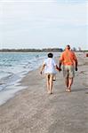 Rear view of senior couple walking on the beach.