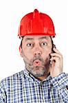 Surprised construction worker with hardhat while talking with phone isolated on a white background