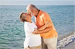 Passionate senior couple kissing on the beach.