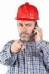 Angered construction worker with hardhat while talking with phone isolated on a white background. Eyes on focus