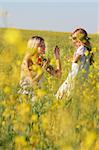happy mother and daughter in traditional clothes in yellow flowers