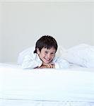 Kid smiling in a white bed